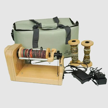 Spinning wheel with yarn, bobbins, and carrying bag for fiber arts and spinning projects.